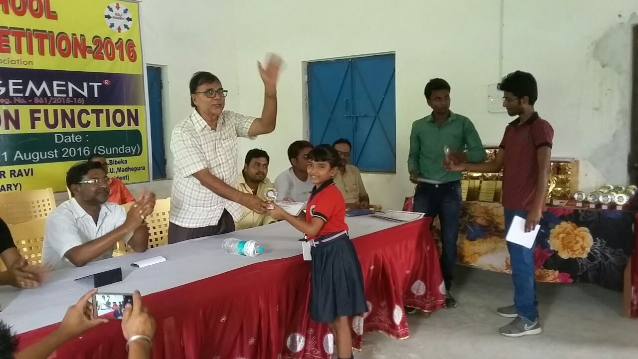 Patron Dr.Bhupendra Madhepuri giving medal-momento and certificate to 'Naisa' from Little Bird School, Shahid Chulhai Marg, Madhepura.